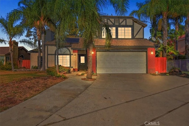 1520 W Norwood St, Rialto, CA 92377 - view of front facade featuring concrete driveway, an attached garage, fence, stucco siding, and solar panels