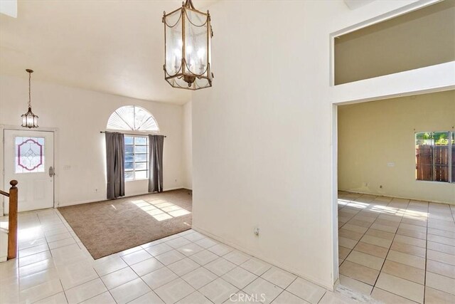 tiled foyer entrance featuring a high ceiling and a notable chandelier