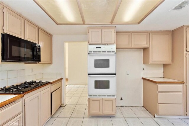 kitchen with gas cooktop, backsplash, double oven, tile countertops, and light tile patterned flooring