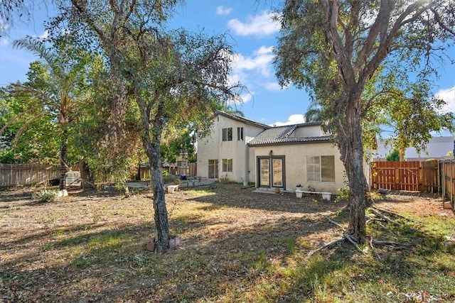 1520 W Norwood St, Rialto, CA 92377 - rear view of house featuring a fenced backyard, a tile roof, french doors, and stucco siding