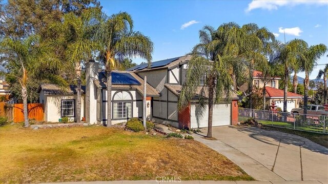 view of front of house with solar panels, a garage, and a front yard