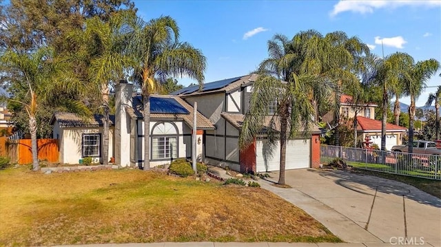 1520 W Norwood St, Rialto, CA 92377 - view of front facade with roof mounted solar panels, fence, a front lawn, concrete driveway, and a garage
