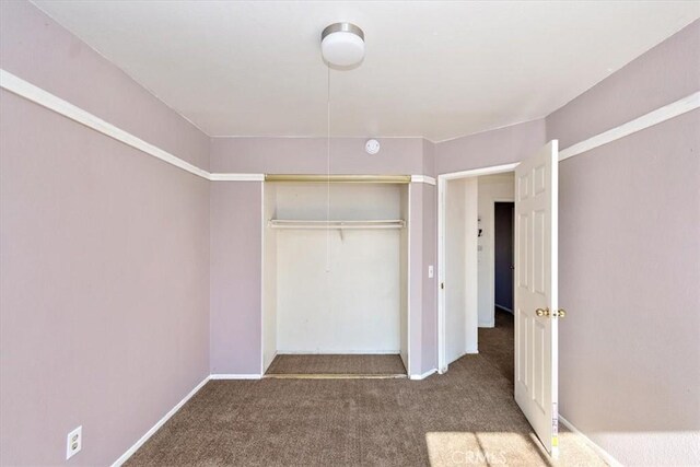 unfurnished bedroom featuring carpet floors and a closet