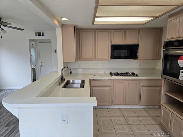 1520 W Norwood St, Rialto, CA 92377 - kitchen featuring oven, visible vents, a sink, black microwave, and a peninsula