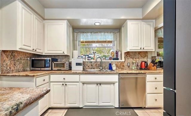 kitchen with sink, white cabinets, stainless steel appliances, and light tile patterned floors