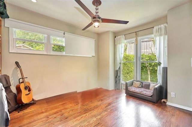 sitting room with hardwood / wood-style flooring, ceiling fan, and a healthy amount of sunlight