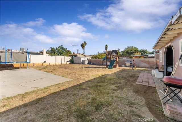 view of yard featuring a playground, a patio, a trampoline, and a shed