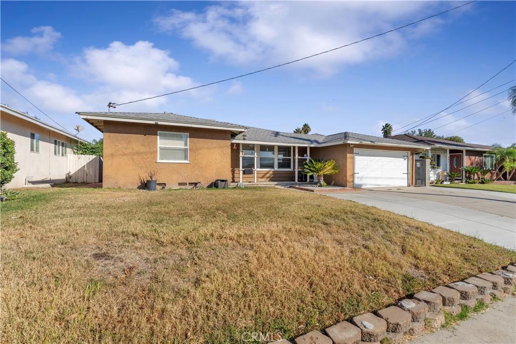 ranch-style house with a garage and a front yard