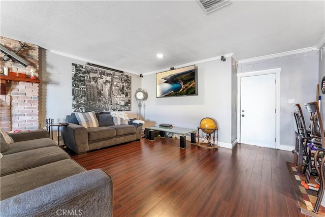 living room with a textured ceiling, a fireplace, ornamental molding, and dark wood-type flooring