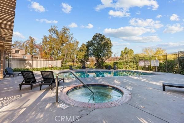 view of pool featuring a patio and a hot tub