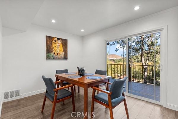 dining area featuring hardwood / wood-style flooring and crown molding