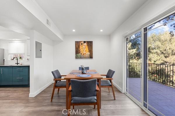 dining space featuring light wood-type flooring and electric panel