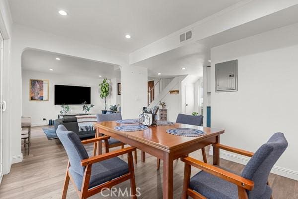 dining room with electric panel and light hardwood / wood-style flooring