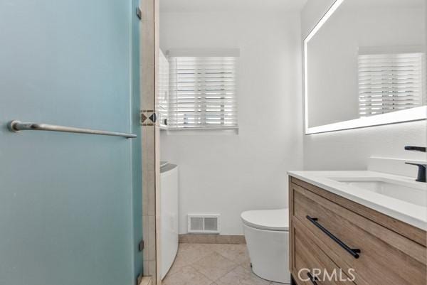 bathroom with a shower with door, vanity, and toilet