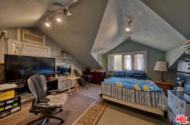 bedroom featuring a textured ceiling, rail lighting, and vaulted ceiling