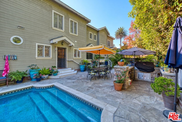 rear view of property featuring a patio area and exterior kitchen