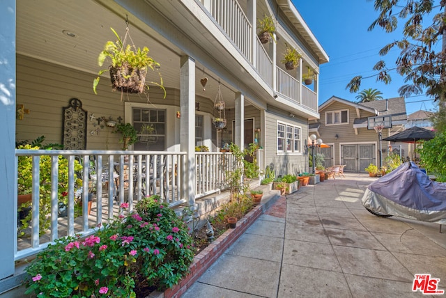 view of patio featuring a balcony and a porch