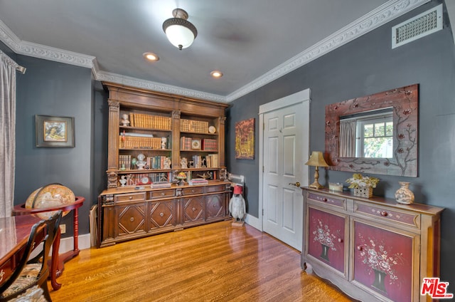 interior space featuring light hardwood / wood-style floors and crown molding