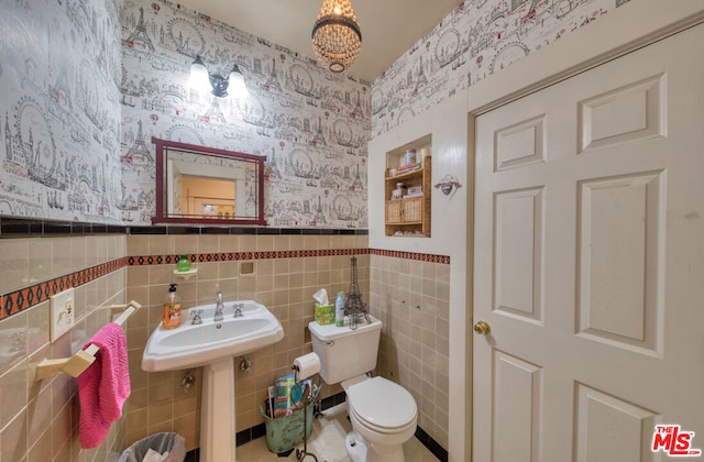 bathroom with sink, tile walls, and toilet