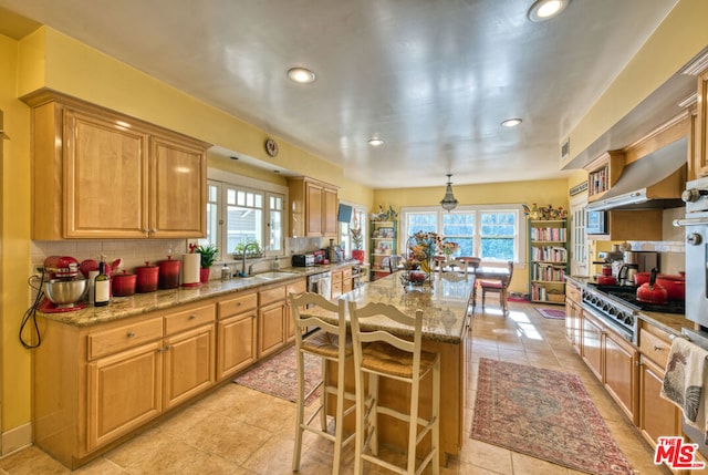 kitchen with a wealth of natural light, a kitchen island, hanging light fixtures, and extractor fan