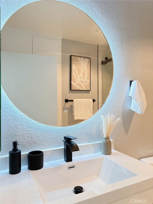 bathroom with a textured wall and a sink