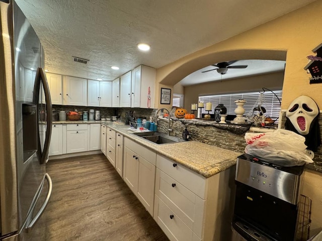 kitchen with white cabinets, sink, hardwood / wood-style flooring, tasteful backsplash, and stainless steel fridge with ice dispenser