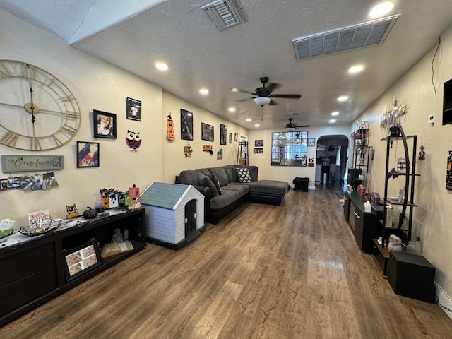 living room with hardwood / wood-style floors, a textured ceiling, and ceiling fan