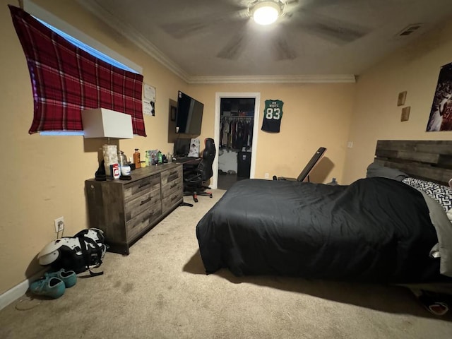 carpeted bedroom featuring a closet, a spacious closet, ceiling fan, and crown molding