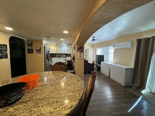 kitchen with white cabinets, refrigerator, stainless steel refrigerator with ice dispenser, dark hardwood / wood-style floors, and a textured ceiling