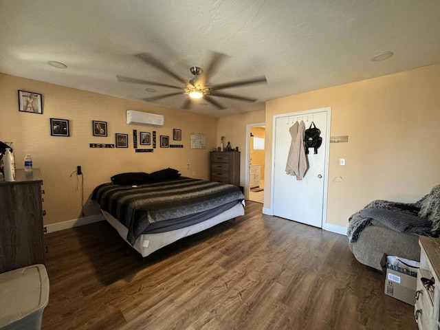 bedroom featuring ceiling fan, dark hardwood / wood-style floors, a wall unit AC, and a closet