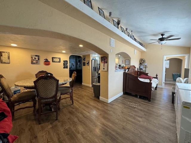 dining area featuring a textured ceiling, lofted ceiling, ceiling fan, and dark hardwood / wood-style floors