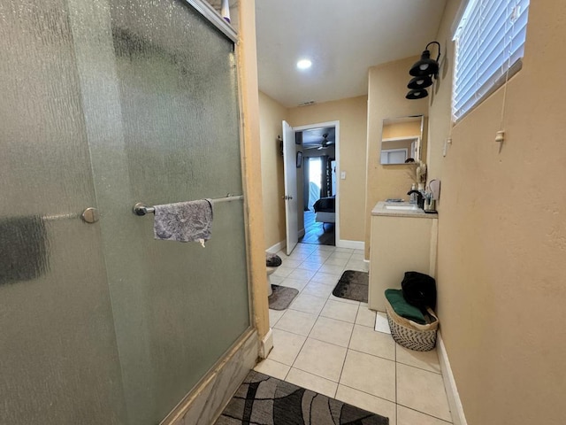 bathroom featuring tile patterned flooring, vanity, walk in shower, and a healthy amount of sunlight