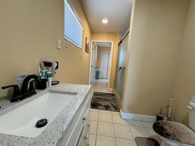 bathroom with tile patterned floors, vanity, toilet, and walk in shower