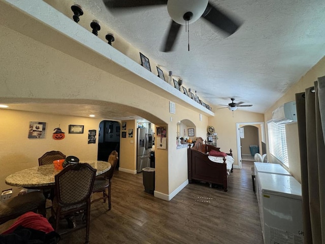 dining area featuring ceiling fan, dark hardwood / wood-style floors, an AC wall unit, a textured ceiling, and lofted ceiling