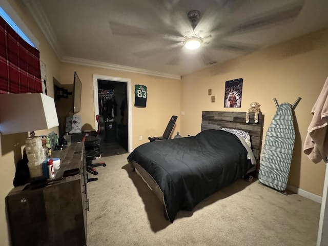 carpeted bedroom with a closet, a spacious closet, ceiling fan, and crown molding