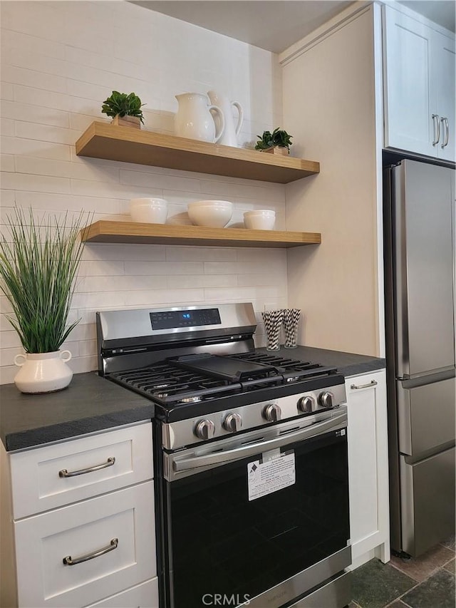 kitchen featuring white cabinets, decorative backsplash, and stainless steel appliances