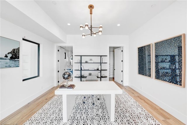 office area with light wood-type flooring and an inviting chandelier