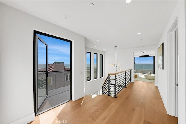 hallway featuring a water view and wood-type flooring