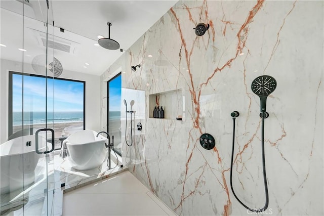 bathroom with a view of the beach, shower with separate bathtub, and a water view