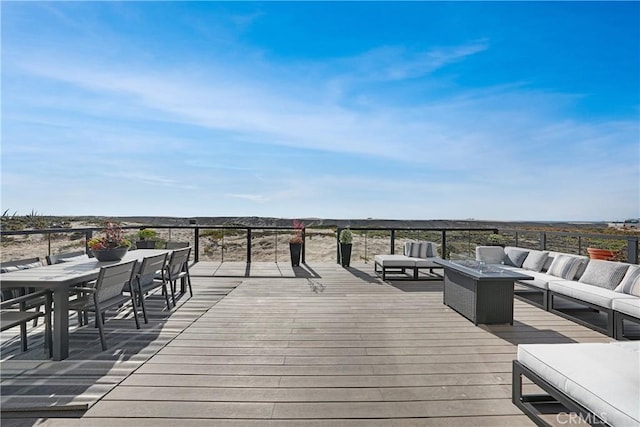 wooden terrace with an outdoor living space with a fire pit