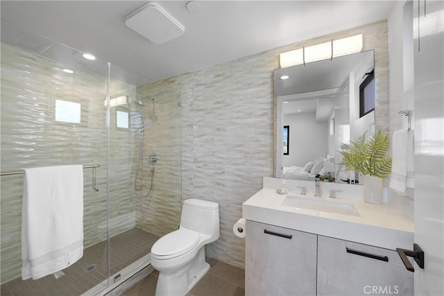 bathroom with toilet, tile walls, tile patterned floors, an enclosed shower, and vanity