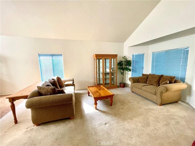 living area featuring high vaulted ceiling and carpet flooring