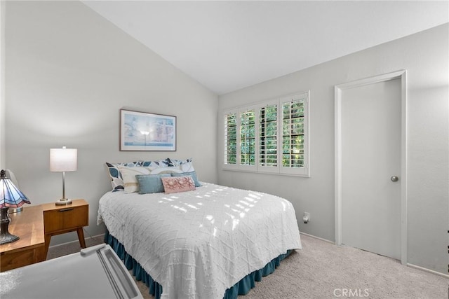 carpeted bedroom with lofted ceiling