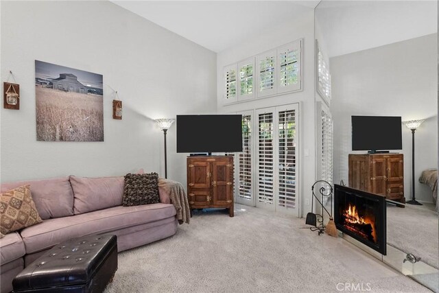 living room with carpet flooring and high vaulted ceiling