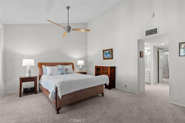 carpeted bedroom featuring ceiling fan, high vaulted ceiling, and ensuite bath