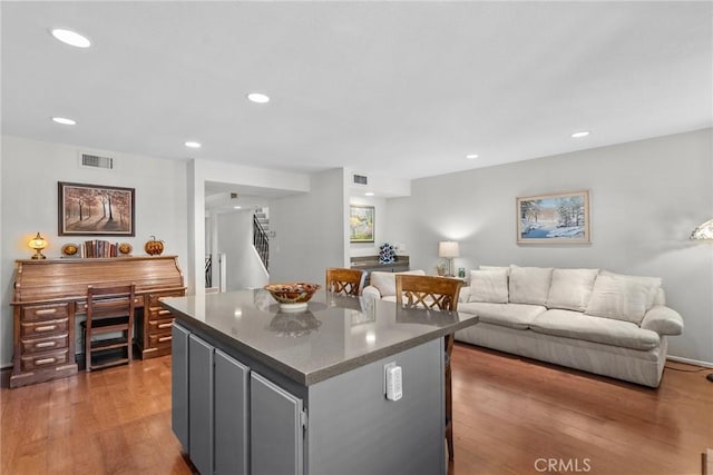 kitchen with gray cabinetry, a kitchen island, and wood-type flooring