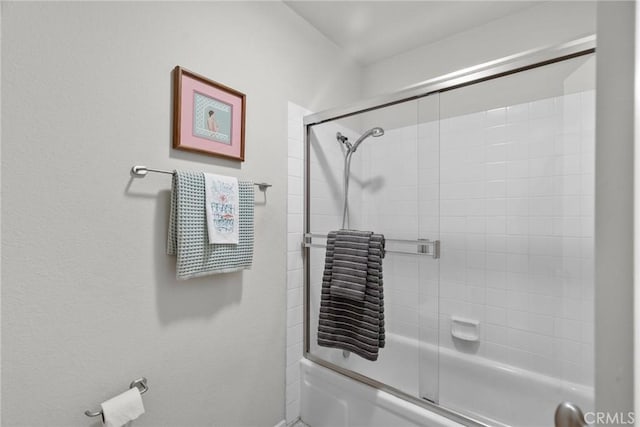 bathroom with bath / shower combo with glass door