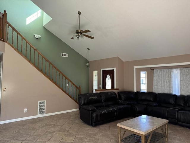 tiled living room featuring ceiling fan and high vaulted ceiling