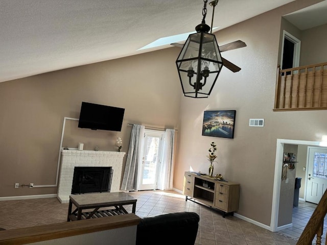 living room featuring light tile patterned flooring, lofted ceiling, and a brick fireplace