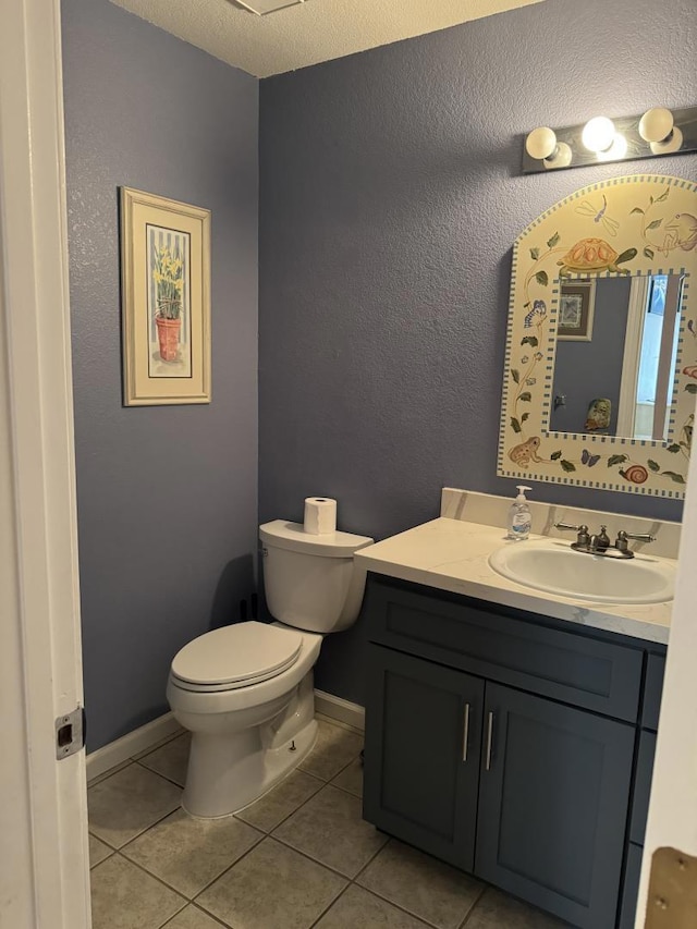 bathroom with vanity, a textured ceiling, tile patterned floors, and toilet